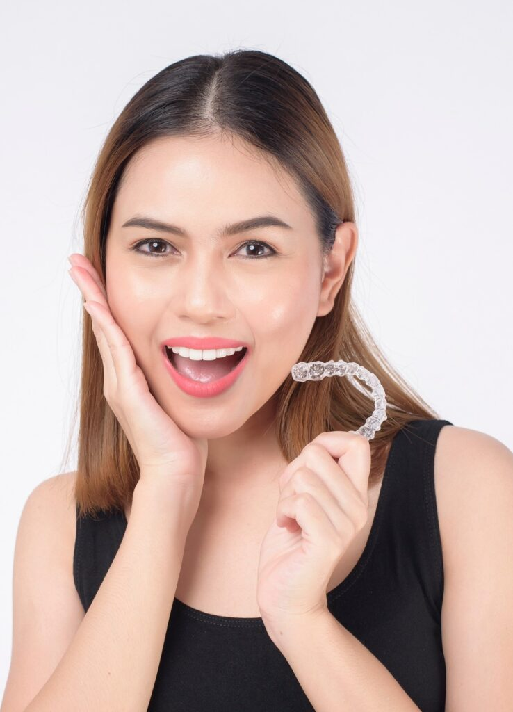 Patient holding an Invisalign clear aligner