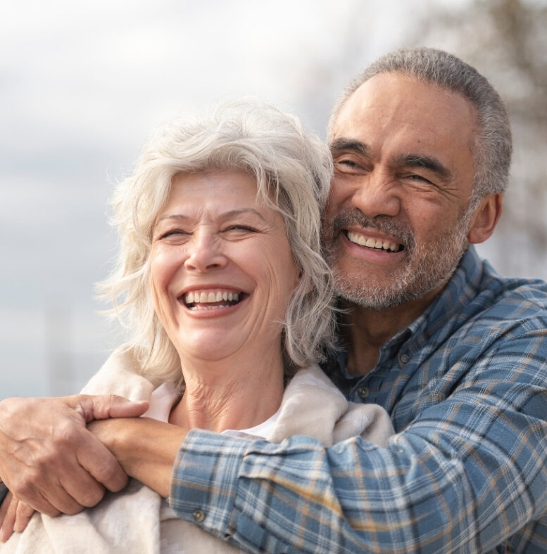 Smiling mature couple after dental implant treatment