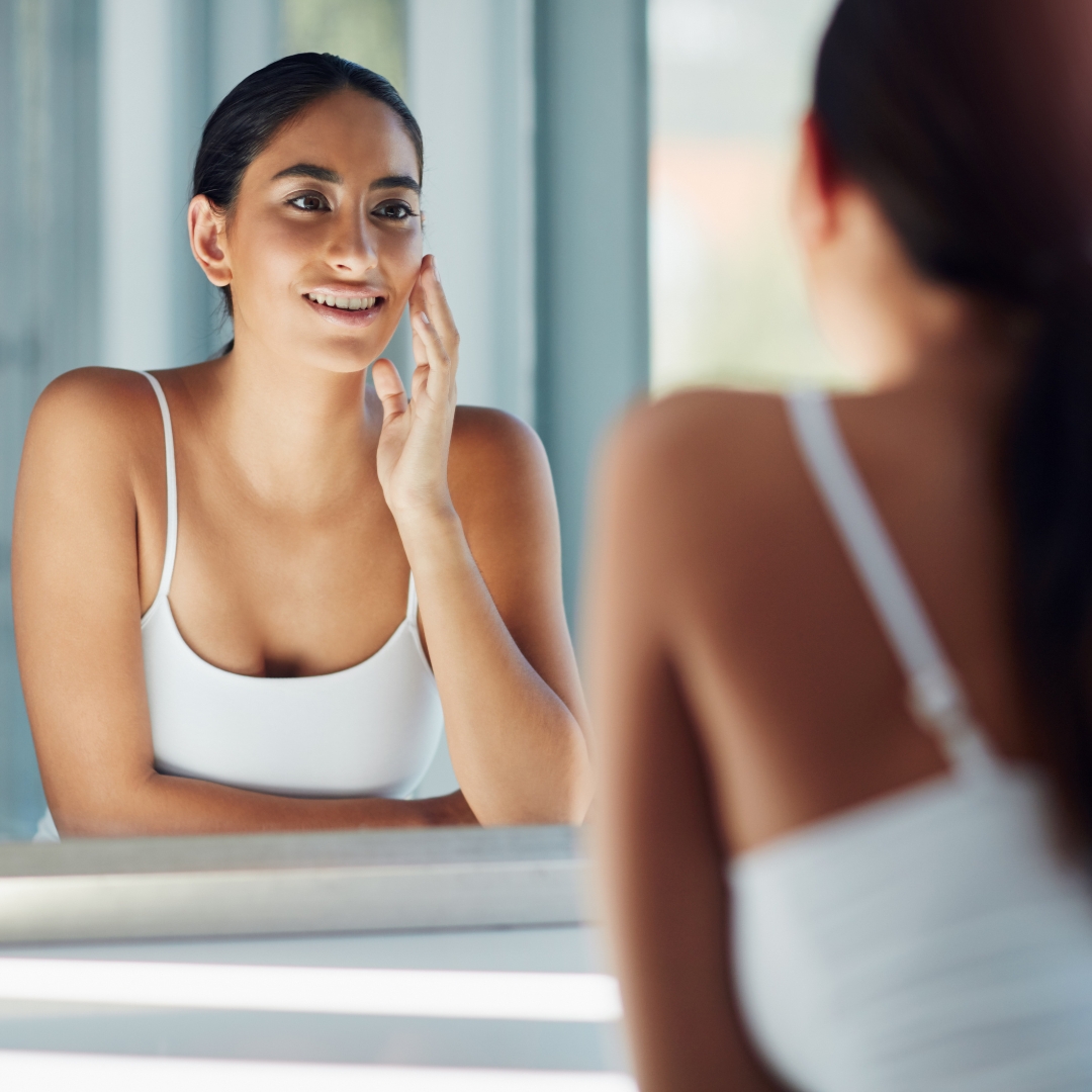 Woman admiring rejuvenated skin in a mirror